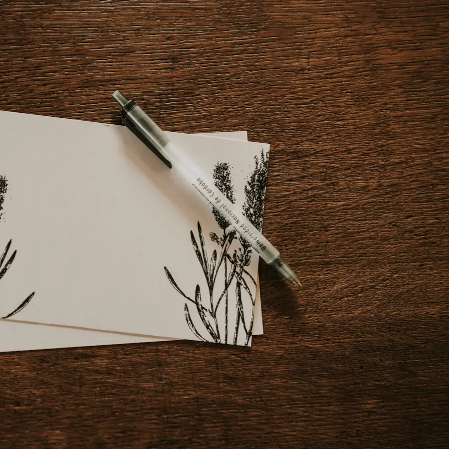 Tarjetas en blanco y una pluma sobre una mesa de madera oscura.