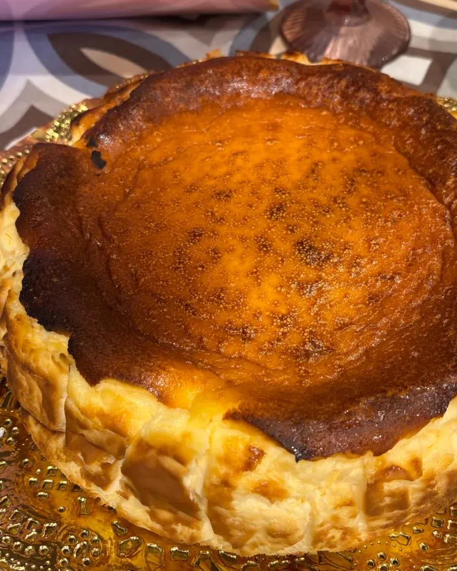 Primer plano de la superficie tostada de la tarta de queso, con los bordes cuajados a la vista.